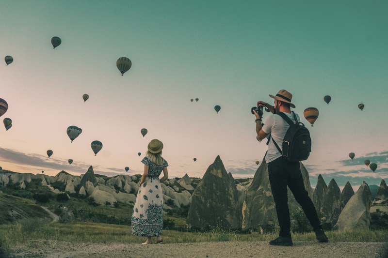 Travelers admiring hot air balloons on vacation